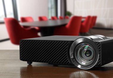 Modern video projektörü konferans odasındaki ahşap masada.