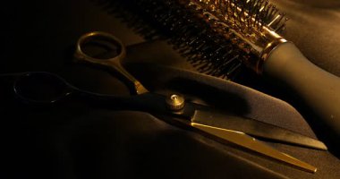 Makas ve siyah kumaşta yuvarlak fırça, yakın plan. Işığın yönü değiştiriliyor