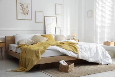 Şık bir odada yumuşak çarşafları olan rahat bir yatak. Ev tekstili