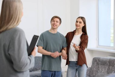 Emlakçı ve evde genç bir çift, seçici odaklı.