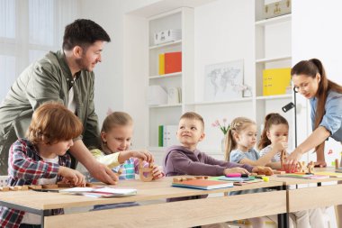 Çocuklar içeride öğretmenlerden ders alıyorlar.