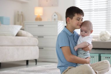 Evde yerde kucaklaşan sevimli küçük kardeşler. Metin için boşluk