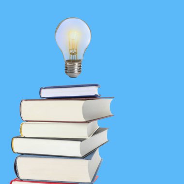 Açık mavi arka plandaki kitap yığınının üzerinde havadaki ampul. Fikir ve bilgi