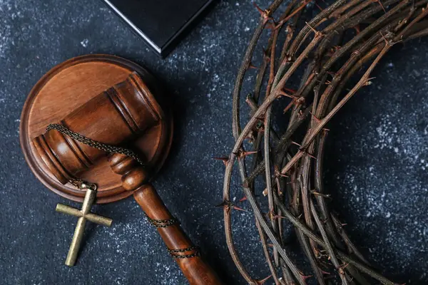 Dikenli taç ve hakimin tokmağı. Arka planda haç var. Yakın plan.