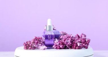 Sabun çubuklu yuvarlanan podyum, esaslı yağ ve leylak çiçekleri beyaz masada, menekşe arka planında, yakın plan
