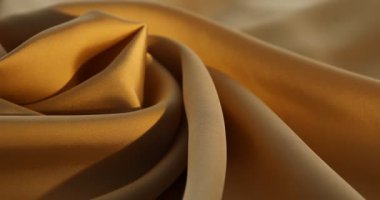 Arka plan olarak buruşuk bej ipek kumaş, yakın plan. Işığın yönü değiştiriliyor