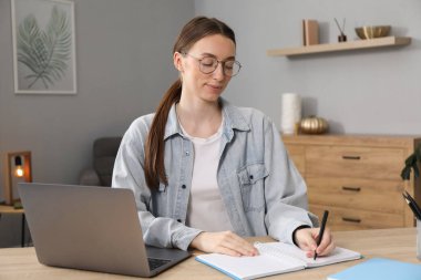 İçerideki masada ders sırasında not alan bir kadın. Kendi kendine çalışma.
