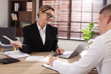 Bankacıyla ofisinde toplantı yapan bir adam.