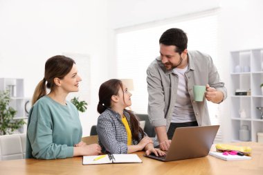 Aileler kızlarına ev ödevlerinde yardım ediyorlar.