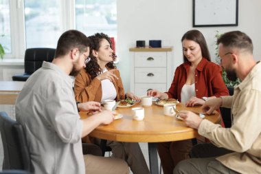 İş arkadaşları öğle arasında ofiste sohbet ediyorlar.