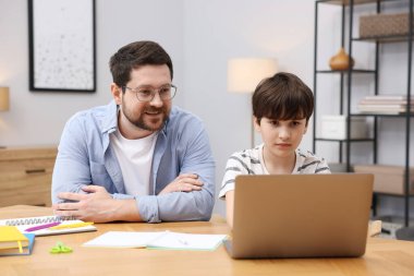 Baba, oğluna ev ödevlerinde yardım ediyor.