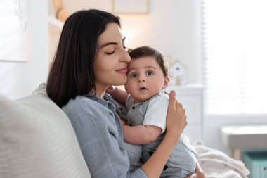 Anne, evdeki kanepede tatlı bebeğiyle.