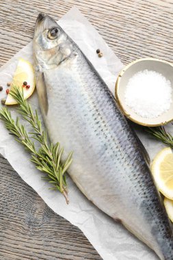 Tuzlu ringa balığı ve baharatlar ahşap masada, düz yatıyordu.