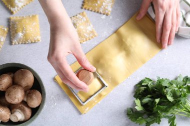 Işık masasında ravioli kesen kadın, üst manzara.