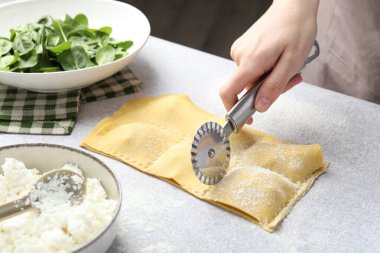 Işık masasında ravioli kesen kadın, yakın plan.