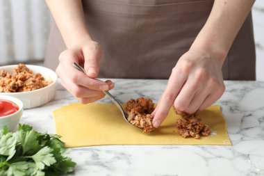 Beyaz mermer masada ravioli yapan kadın, yakın plan.