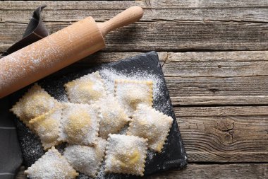 Pişmemiş ravioli ve ahşap masa üzerinde merdane, üst manzara. Metin için boşluk