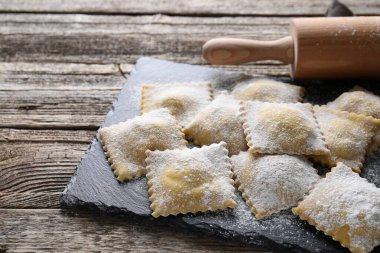 Pişmemiş ravioli ve merdane ahşap masada, yakın plan.