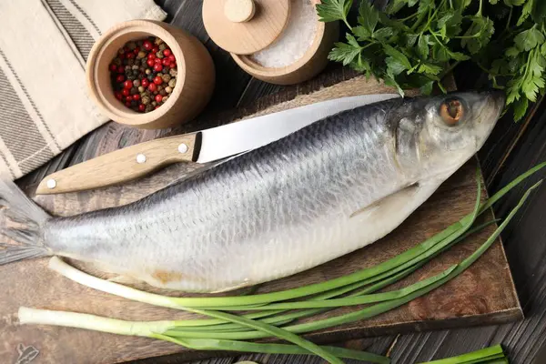 Lezzetli ringa balığı, ahşap masada baharatlar, düz uzanmış.