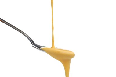 Lezzetli erimiş peynir beyaz kaşığa akıyor.