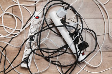 Eklenti güç panoları ahşap zemindeki prizlerle aşırı yüklenmiş, üst görünüm