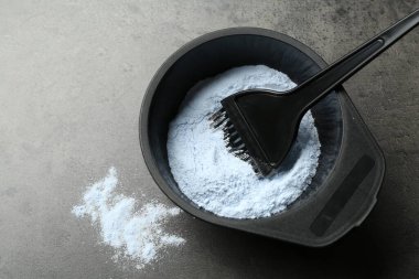 Saçını ağartma tozu ve fırçayla boyamış bir kâse.