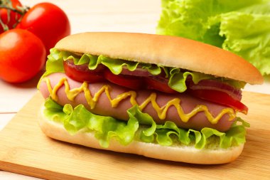 Lezzetli sosisli, domates, soğan, marul ve hardal, yakın plan.