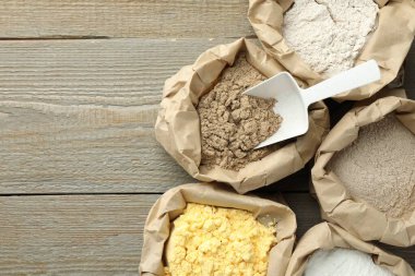 Tahta masadaki kağıt torbalarda farklı türde un var. Metin için boşluk