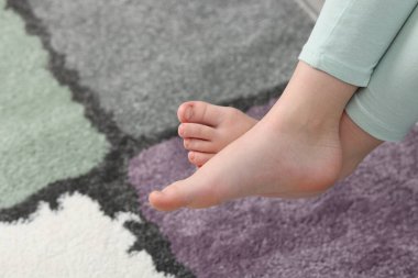 Evdeki yumuşak halının üstündeki kız, yakın plan. Metin için boşluk