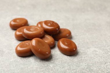 Gri masada bir sürü lezzetli karamel şekeri, yakın plan.