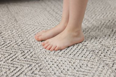 Evdeki gri halıdaki kız, yakın plan.