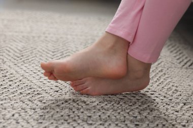 Evdeki gri halıdaki kız, yakın plan.