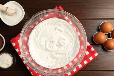 Krem şantili kase ve ahşap masa üzerinde malzemeler, düz yatıyordu.