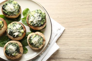 Hafif ahşap masada servis edilen lezzetli mantarlar, üst manzara. Metin için boşluk