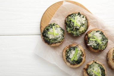 Beyaz ahşap masada servis edilen lezzetli mantarlar, üst manzara. Metin için boşluk