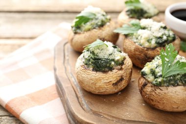 Tahta masada servis edilen lezzetli mantarlar, yakın plan.