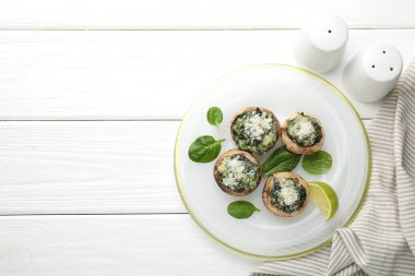 Beyaz ahşap masada servis edilen lezzetli mantarlar, üst manzara. Metin için boşluk
