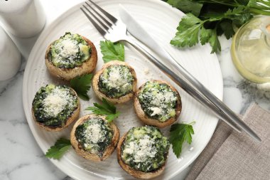 Beyaz mermer masada servis edilen lezzetli mantarlar.