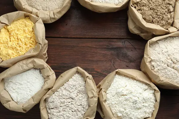 Tahta masada, düz bir zeminde, kağıt torbalarda farklı un türlerinden bir çerçeve. Metin için boşluk