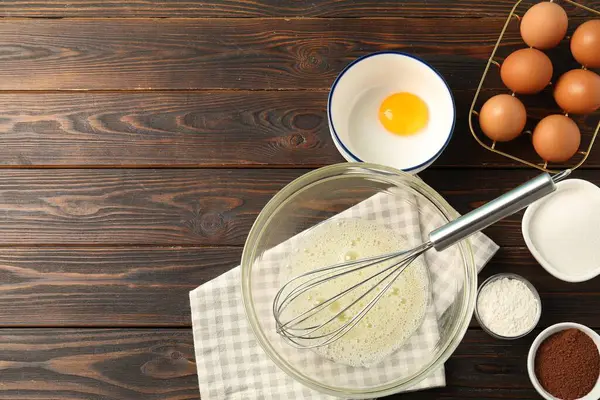 Krem şanti yapıyorum. Tabak, çırpma ve malzemeler ahşap masada, düz yerde. Metin için boşluk