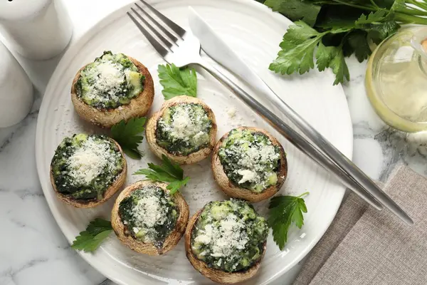 Beyaz mermer masada servis edilen lezzetli mantarlar.