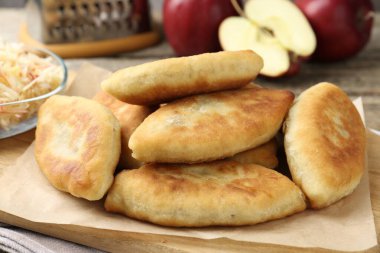 Lezzetli kızarmış pirinçler (doldurulmuş turtalar) ve ahşap masada elmalar, yakın plan.