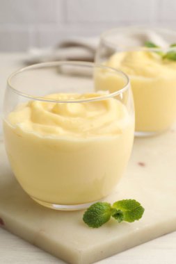 Beyaz masada naneli vanilyalı puding, yakın plan.