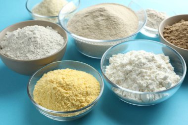 Açık mavi arkaplanda farklı un türleri, yakın plan