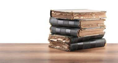 Tahta masadaki eski kitaplar beyaz arka plana karşıdır