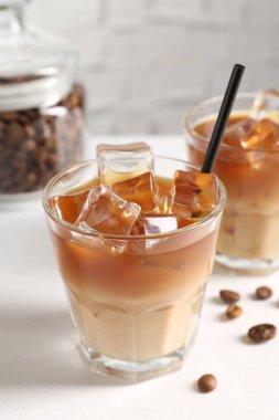 Lezzetli buzlu kahve ve fasulyeler beyaz masada, yakın plan.