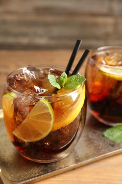 Küba libre kokteylini ahşap masada nane şekeri ile tazeliyorum.