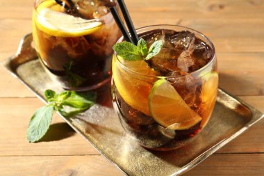 Küba libre kokteylini ahşap masada nane şekeri ile tazeliyorum.