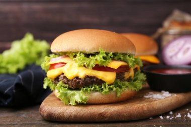 Ahşap masada soslu leziz bir çizburger, yakın plan.