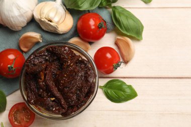 Lezzetli güneşte kurutulmuş domatesler, taze sebzeler, fesleğen ve sarımsak beyaz ahşap masa, düz uzanmış